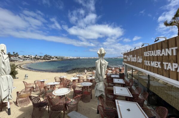 beach restaurant and bar with tables seating on a sunny day with sea view