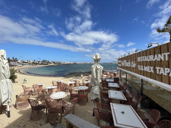 beach restaurant and bar with tables seating on a sunny day with sea view